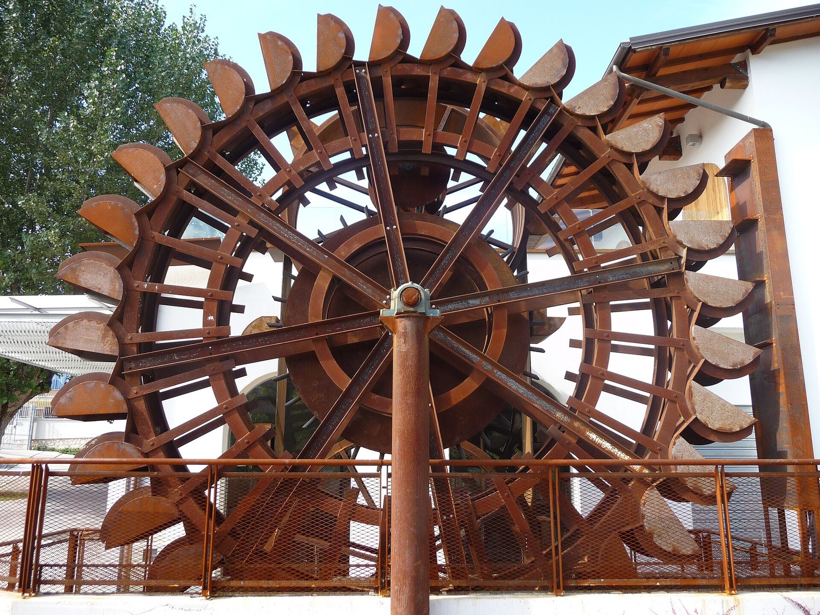 Grande ruota idraulica in legno lungo il fiume, testimonianza dell'industria della valle